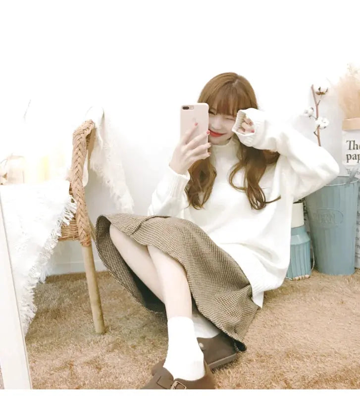 A cozy white knit sweater with long sleeves and a soft, slightly oversized fit