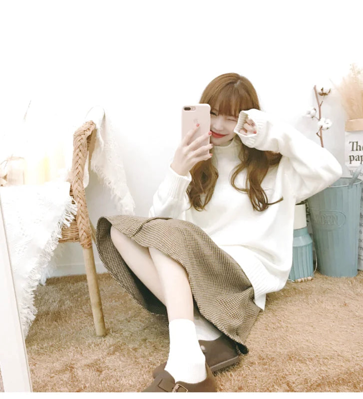 A cozy white knit sweater with long sleeves and a soft, slightly oversized fit