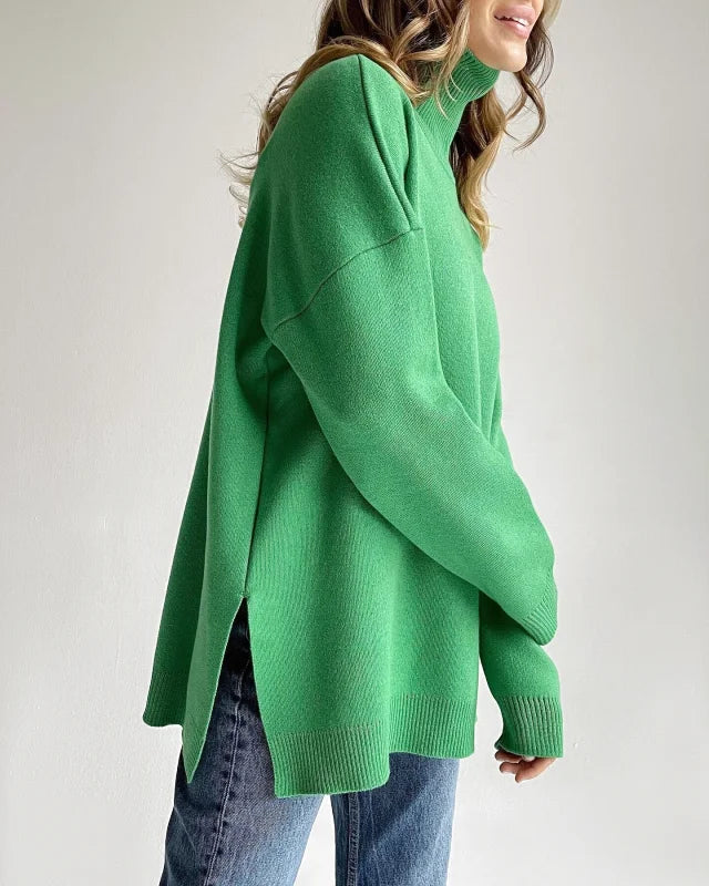 A vibrant green, oversized turtleneck sweater with a soft knit texture and side slits