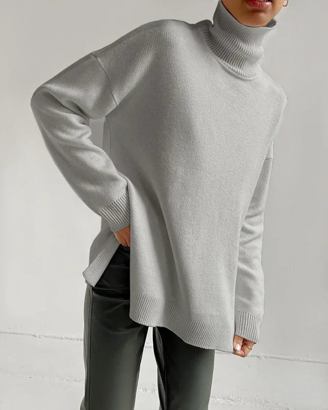 A soft, light gray turtleneck sweater with a relaxed fit and ribbed cuffs