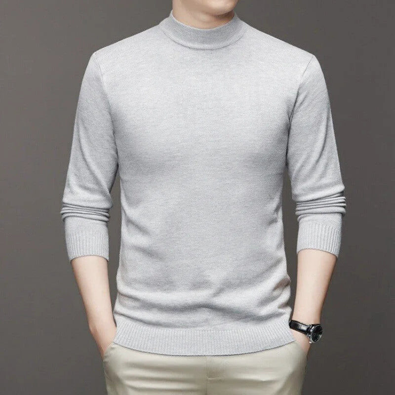 A light gray, long-sleeved turtleneck sweater with ribbed cuffs and hem