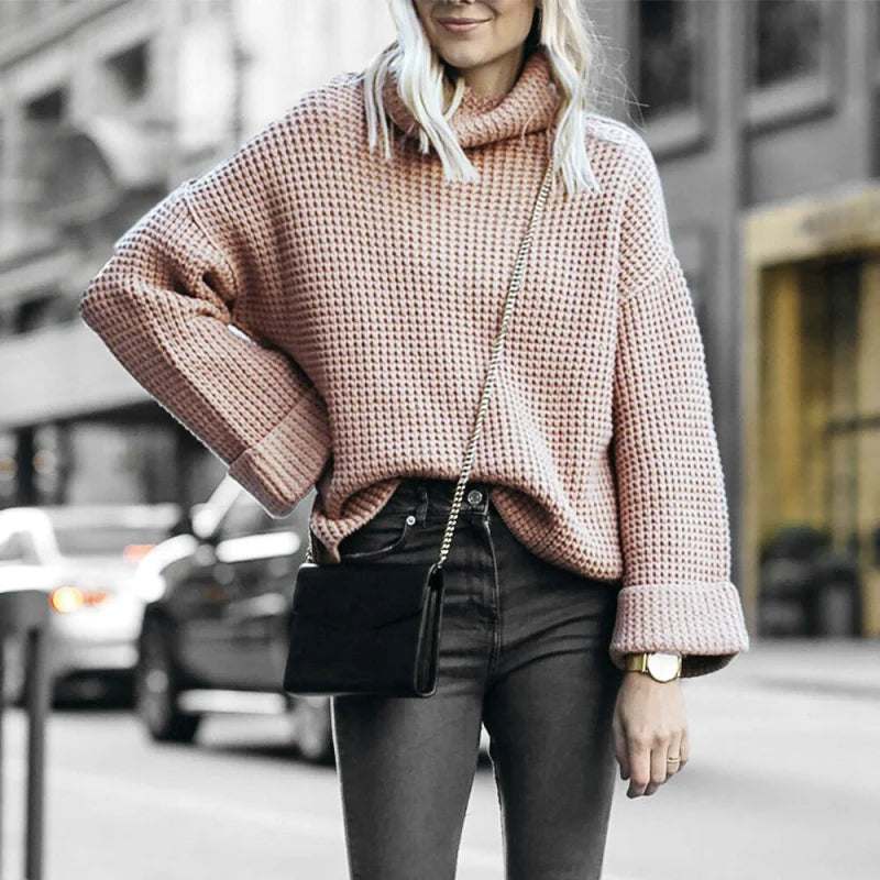 A cozy, dusty rose-colored waffle-knit turtleneck sweater with a relaxed fit and ribbed cuffs
