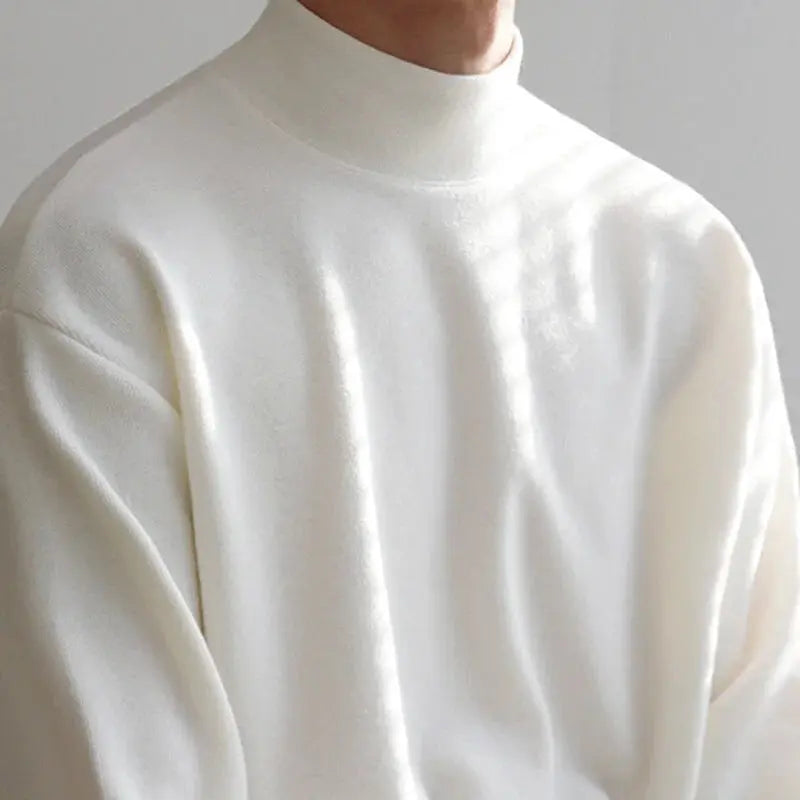 A soft, off-white turtleneck sweater with a relaxed fit and subtle texture