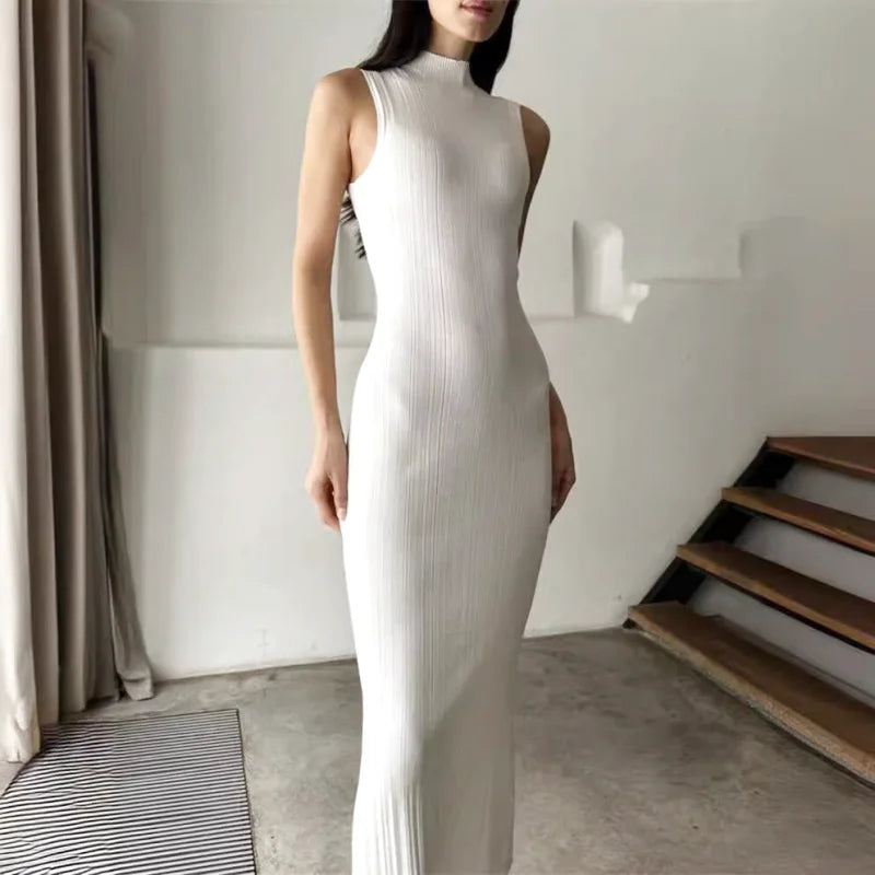 A sleek, white ribbed knit high-neck sleeveless dress with a form-fitting silhouette