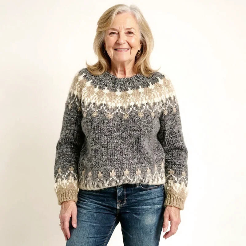 A cozy, chunky-knit sweater in shades of gray and cream with a traditional nordic-inspired pattern