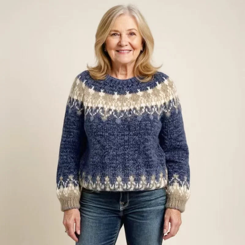 A cozy navy blue and cream-colored knit sweater with intricate fair isle patterns around the neckline, sleeves, and hem
