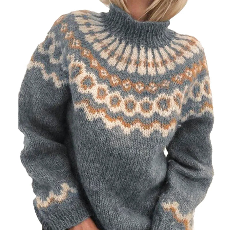 A cozy, chunky-knit sweater in muted gray with intricate geometric patterns in cream and tan across the chest and shoulders