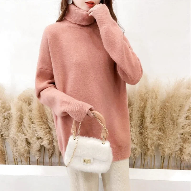 Soft pink turtleneck sweater with a cozy, oversized fit and ribbed cuffs