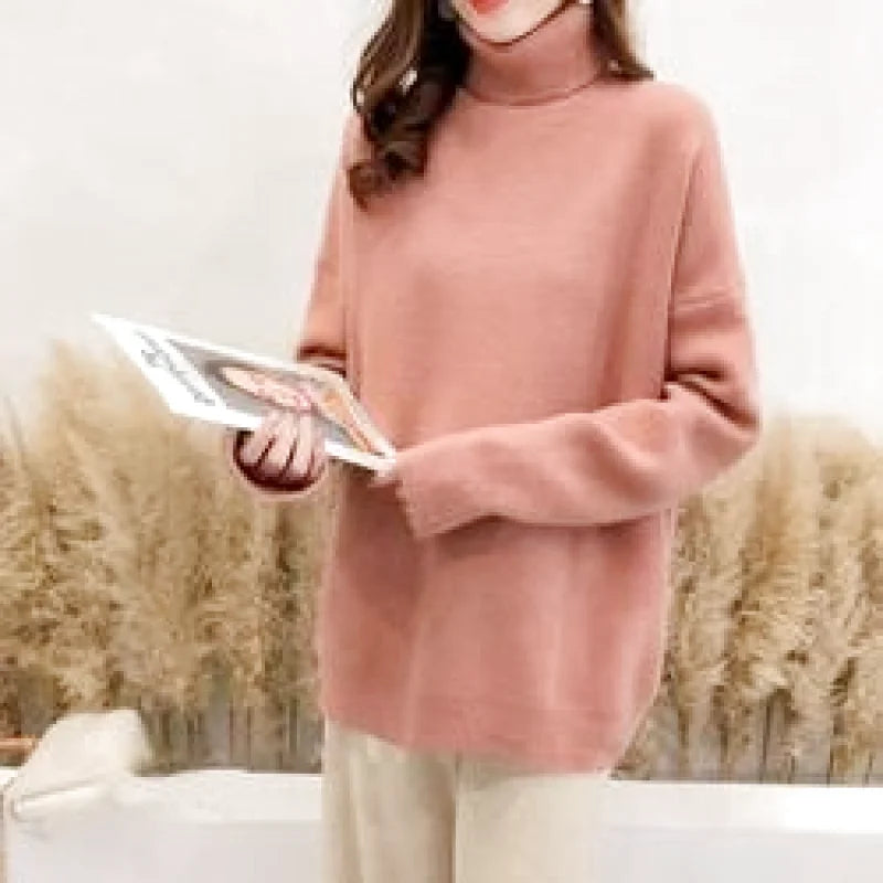 A soft pink, long-sleeved turtleneck sweater with a cozy knit texture