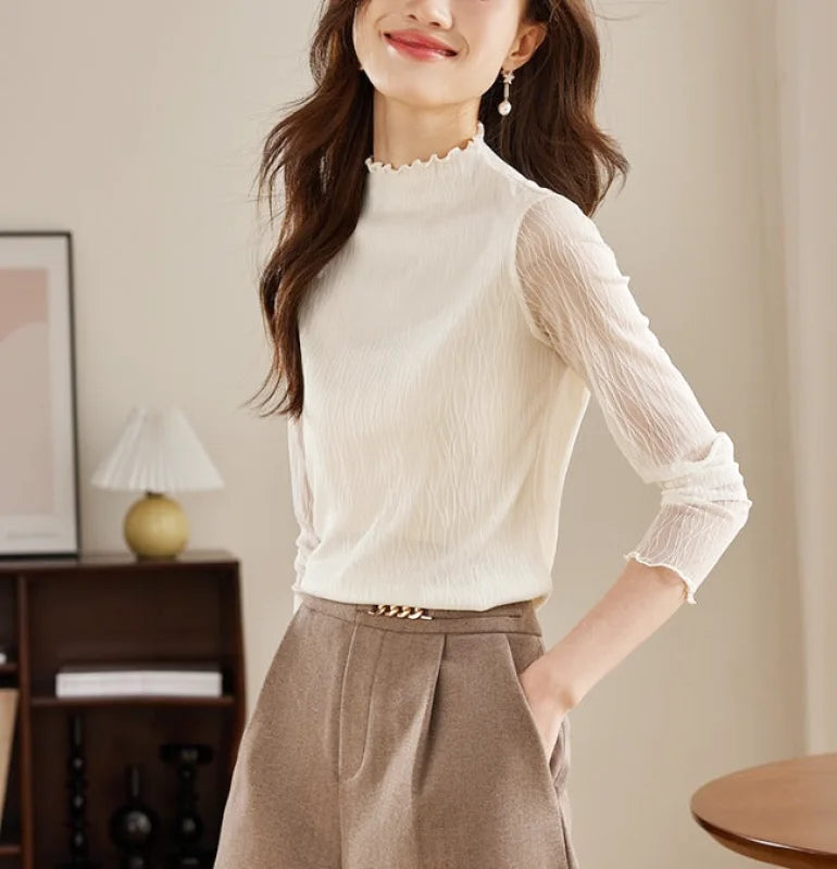 White sheer long-sleeved blouse with a high neckline and ruffled trim
