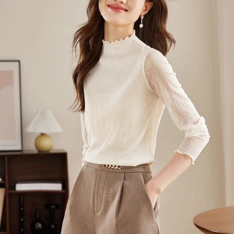 White sheer long-sleeved blouse with a high neckline and ruffled trim