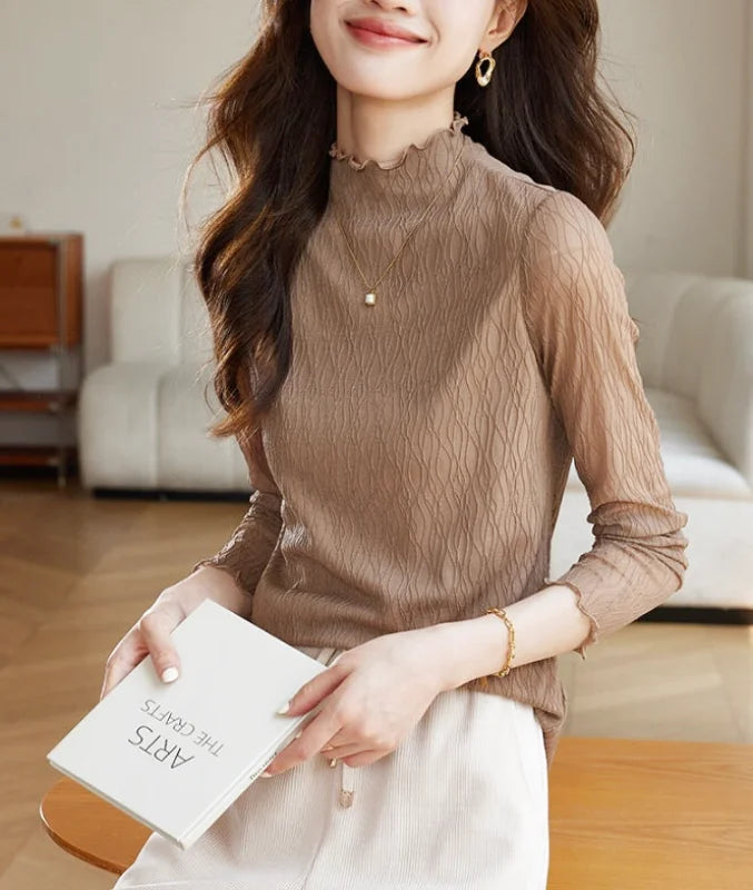 A beige, sheer, long-sleeved top with a high neckline and subtle wavy texture