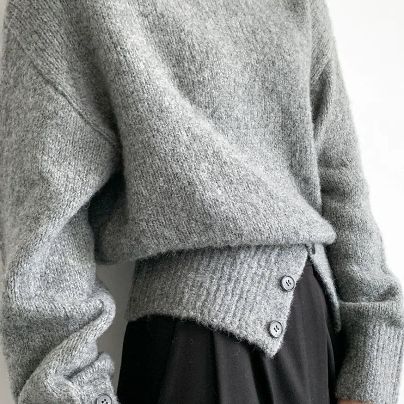 A cozy, heather gray knit sweater with a soft, fuzzy texture and buttoned cuffs