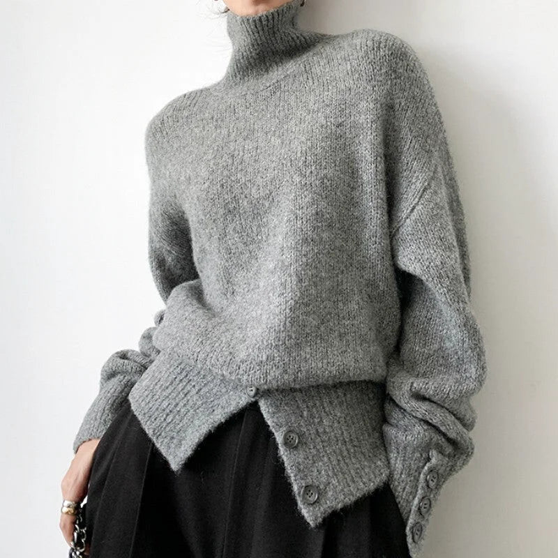 A cozy, oversized gray turtleneck sweater with a textured knit and buttoned cuffs
