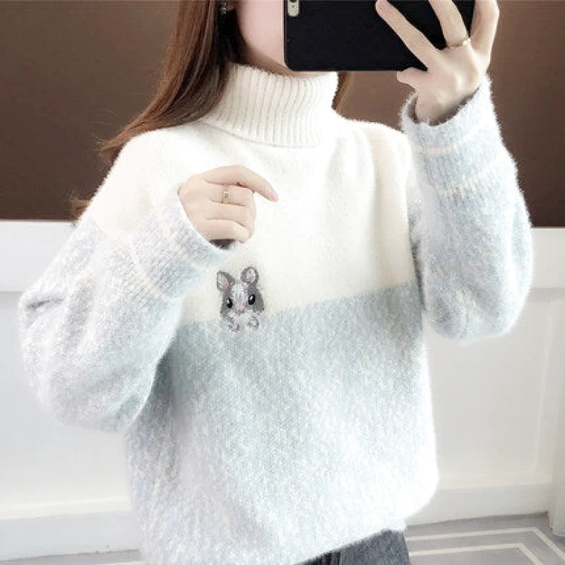 A cozy, two-tone fluffy sweater in soft white and light blue with a cute embroidered mouse detail on the chest
