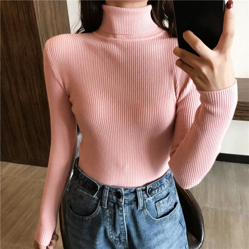 A soft pink ribbed knit turtleneck sweater with long sleeves