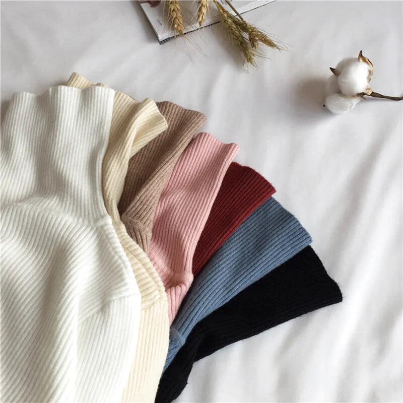 A collection of ribbed knit turtleneck tops in soft, neutral tones including cream, beige, pink, red, blue, and black