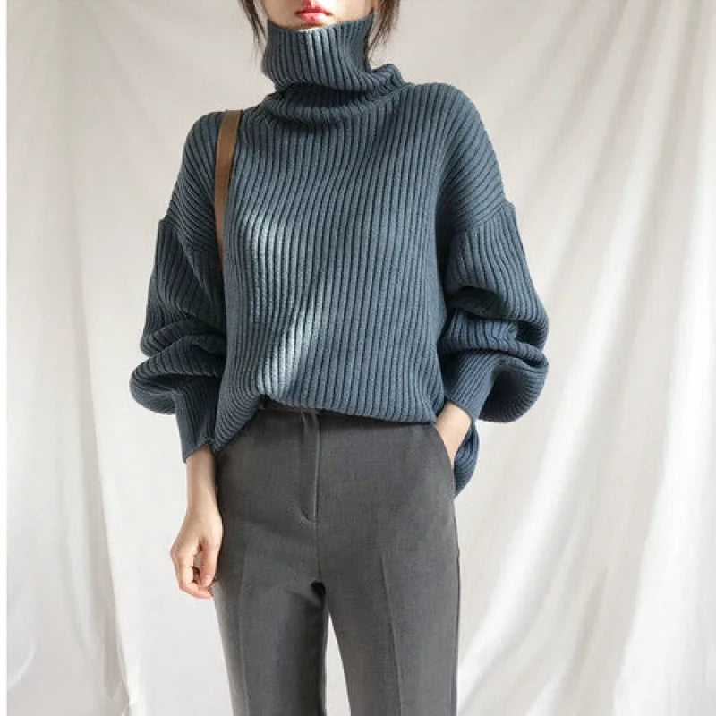 A cozy dark teal ribbed knit turtleneck sweater with voluminous sleeves