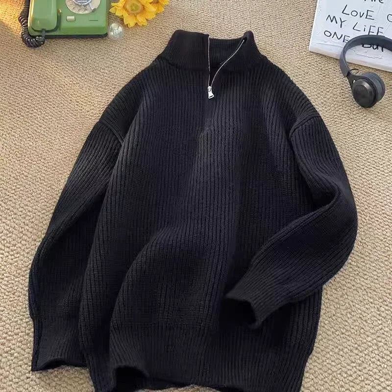 Black ribbed knit sweater with a half-zip collar and long sleeves