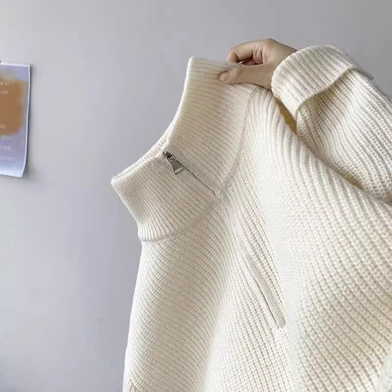 Cream-colored ribbed knit sweater with a high collar and front zipper
