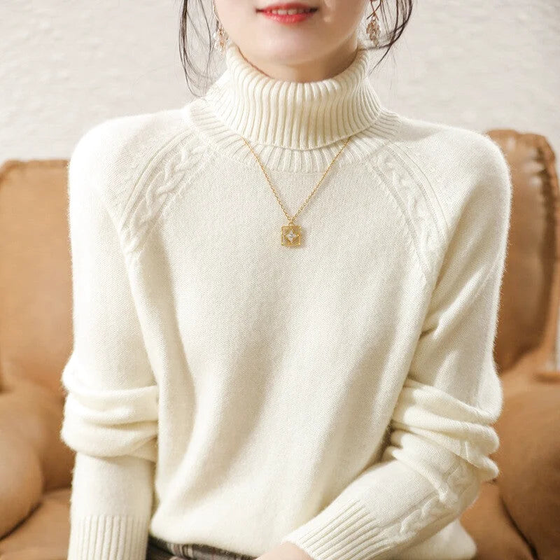 Cream-colored high-neck knit sweater with ribbed cuffs and a subtle cable-knit pattern on the shoulders