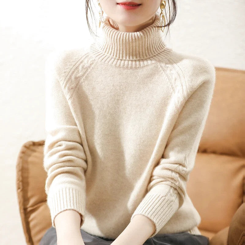 Beige high-neck knit sweater with ribbed cuffs and a subtle cable-knit pattern on the shoulders