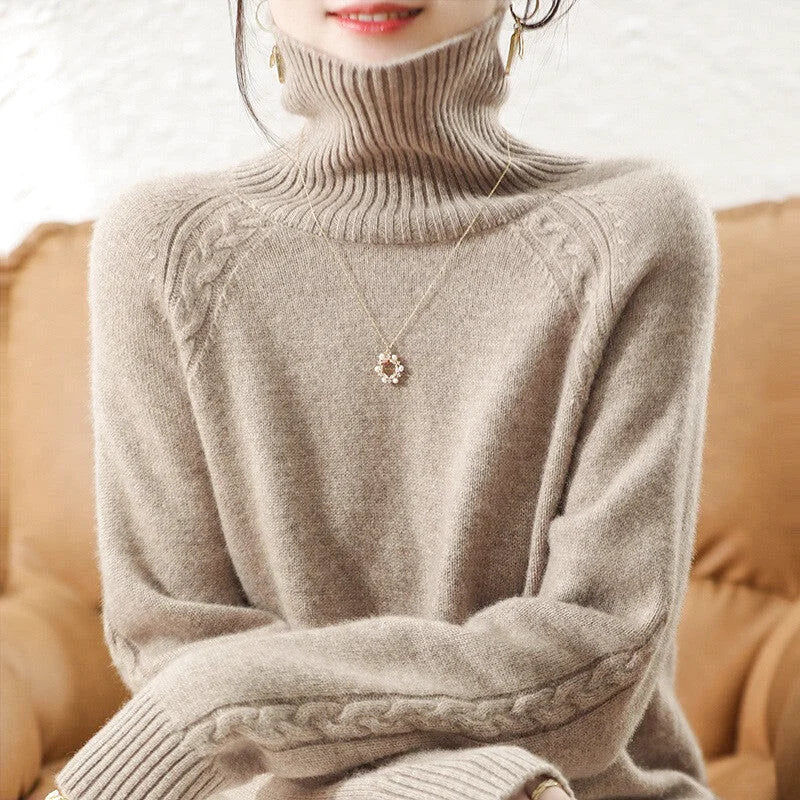 Beige turtleneck sweater with ribbed cuffs and intricate cable-knit detailing on the shoulders