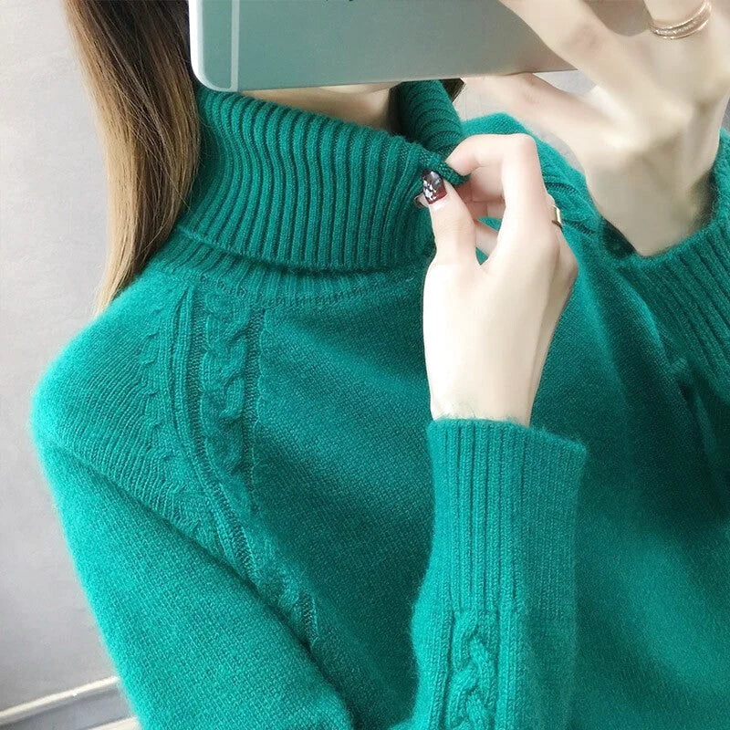 A teal cable-knit turtleneck sweater with ribbed cuffs and neckline