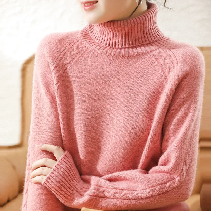 A soft pink turtleneck sweater with ribbed cuffs and a cable-knit pattern along the shoulders