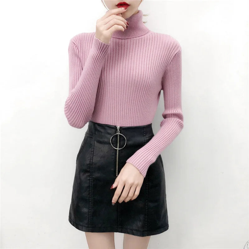 A soft pink ribbed knit turtleneck sweater with long sleeves