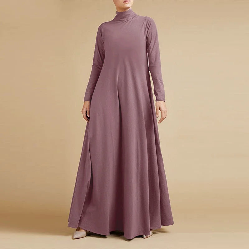A flowing, long-sleeved, high-necked lavender maxi dress with a subtle slit on the side